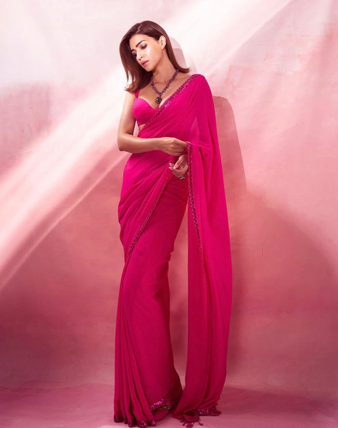 Kriti Sanon
sets the glam quotient high donning a bright pink saree with a thin border. Letting the drape speak volumes she simply accessorises with a showstopping chained neckpiece adding elegance to her appearance.