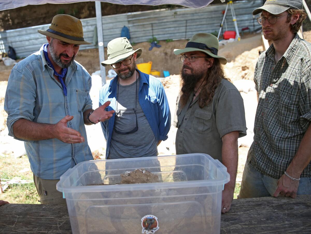 Archaeologist Giorgi Bidzinashvili (L) talks to his colleagues at the excavation site where a presumably dated 1.8-million-year-old lower jawbone belonging to an early species of human was found.