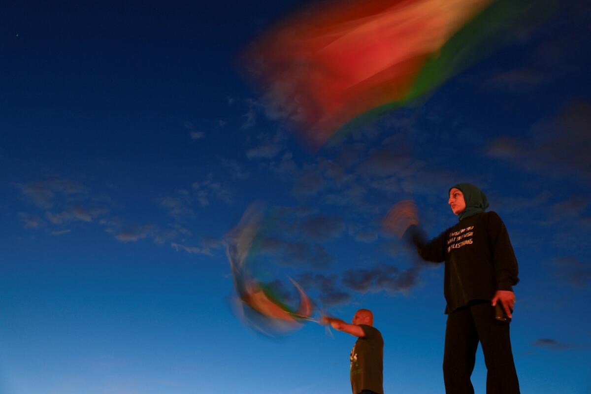 Demonstrators wave Palestinian flags as they take part in a vigil and rally honoring the lives of journalists and medics killed on Monday in Israeli strikes on Nasser hospital in Khan Younis, in the southern Gaza Strip, outside Union Station in Washington