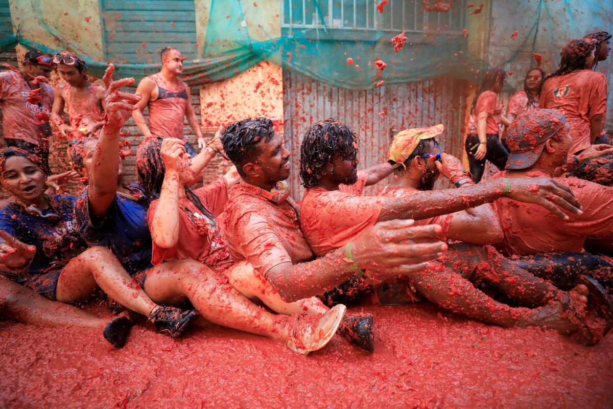 Revellers play in tomato pulp during the annual 'La Tomatina' food fight festival in Bunol, near Valencia, Spain
