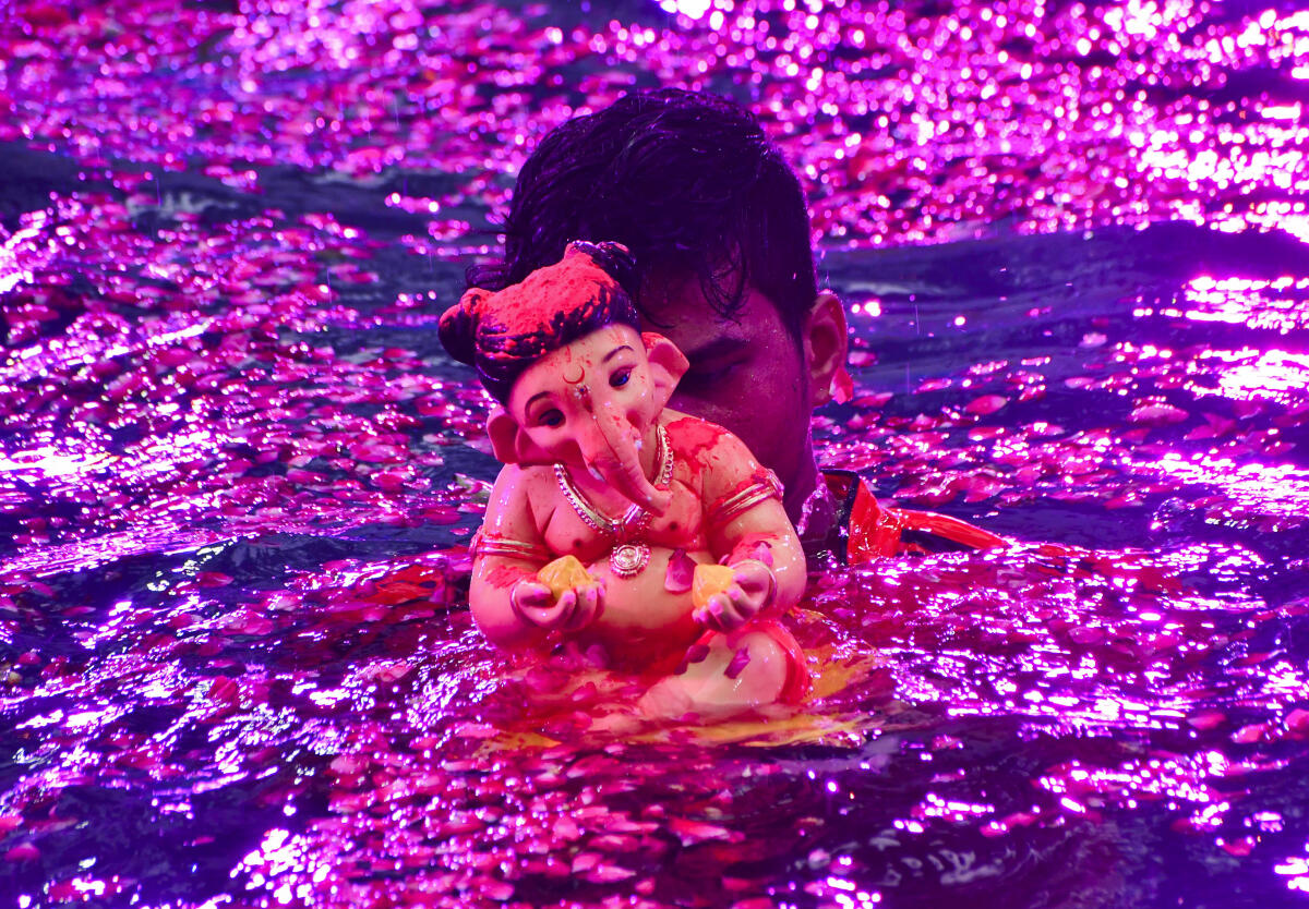 An idol of Lord Ganesh being immersed at an artificial pond after one-and-half day during the Ganesh Chaturthi festival, in Mumbai