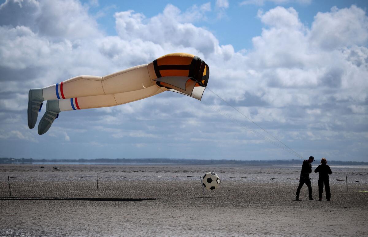 People fly a kite in the shape of a pair of legs on the opening day of the St Anne’s Kite festival at St Anne’s near Blackpool, Britain