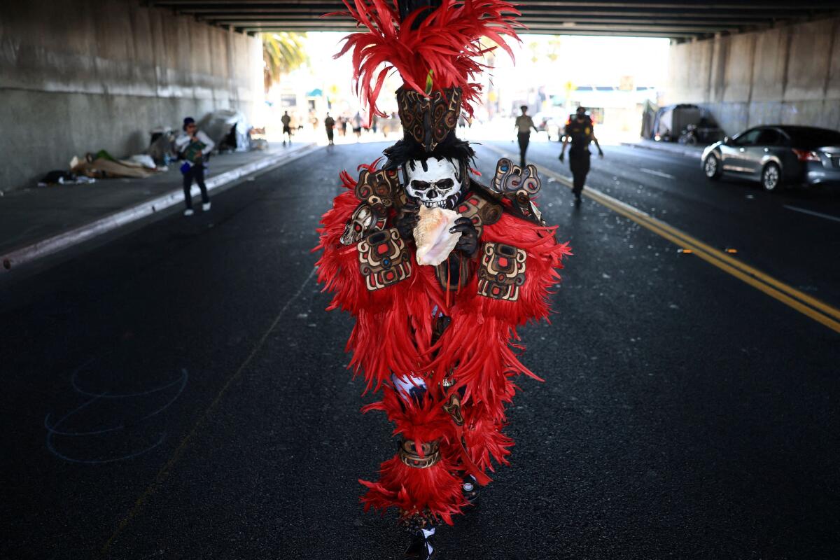 A person in traditional garb marches during the 55th National Chicano Moratorium in Los Angeles, California, US.