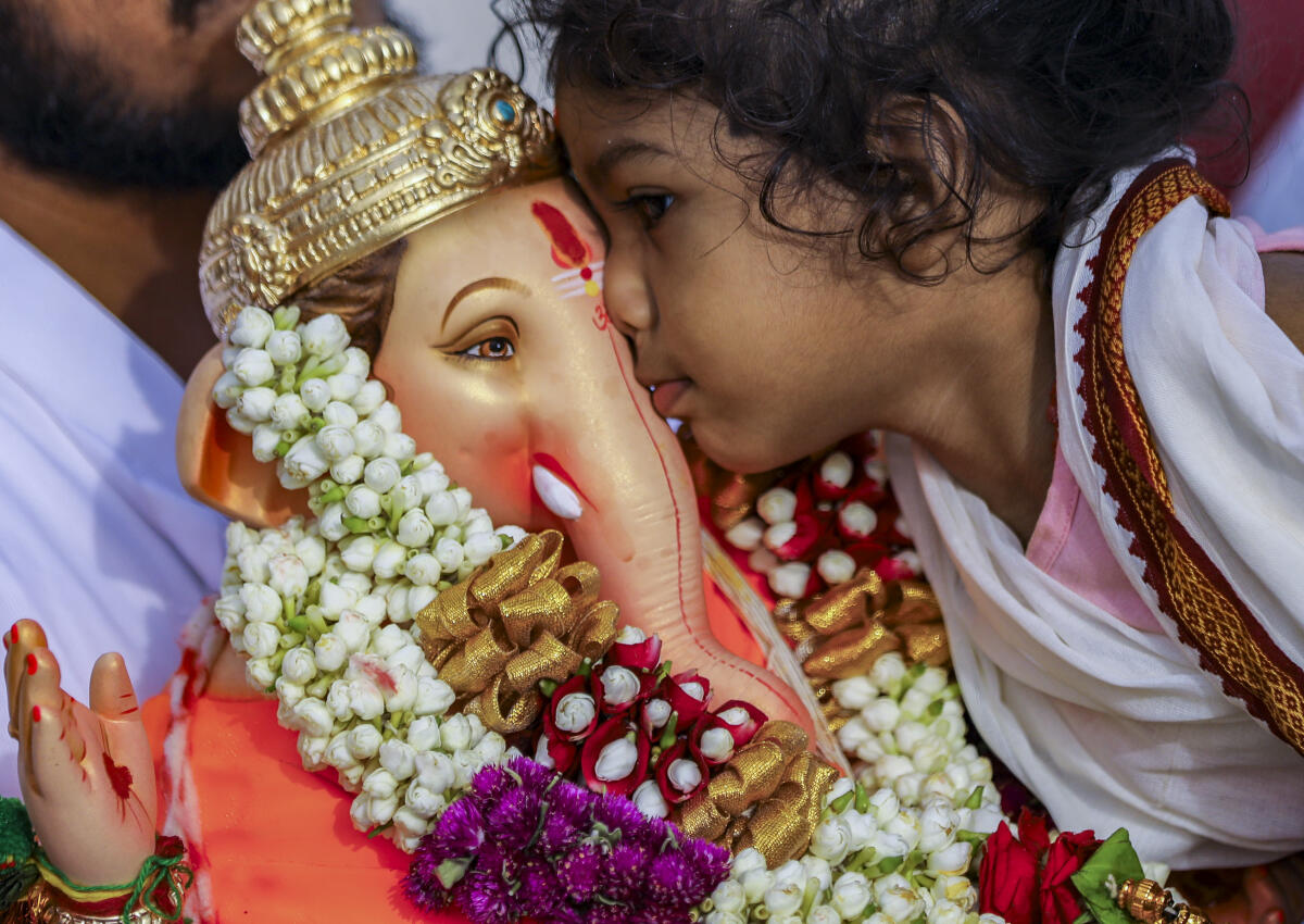 A child greets an idol of Lord Ganesha before immersion during the ‘Ganesh Chathurthi’ festival, in Hyderabad, Telangana