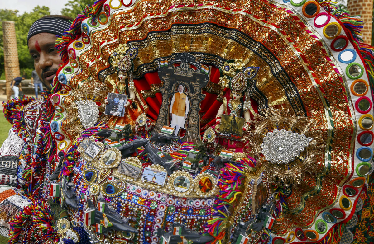 An artist shows an Operation Sindoor themed turban ahead of the upcoming nine-day-long Navratri festival, in Ahmedaba