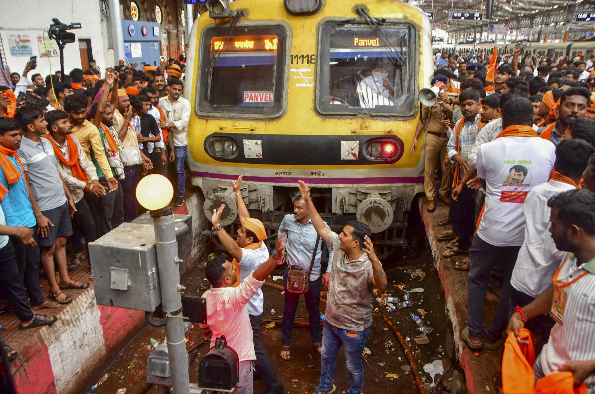 Maratha community members stop a train during their protest seeking reservation for the community under the Other Backward Classes (OBC) category, at Chhatrapati Shivaji Maharaj Terminus (CSMT) in Mumbai