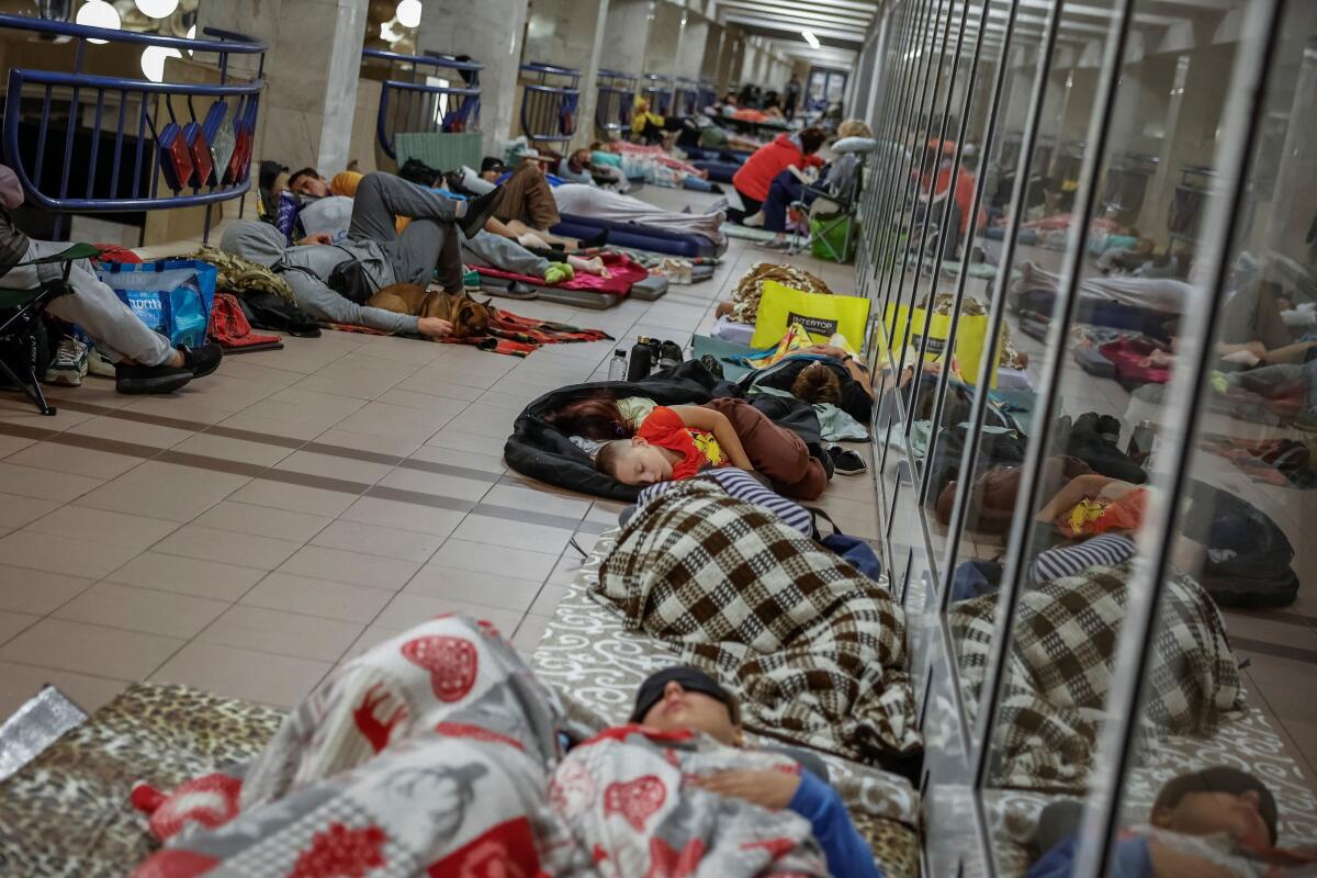 People, including children, take shelter inside a metro station during an overnight air raid alert, amid Russia's attack on Ukraine, in Kyiv.