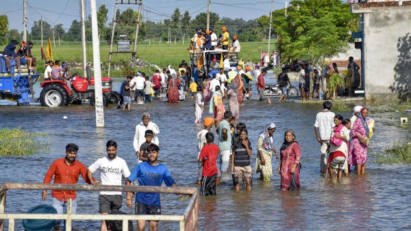 Flood-affected villagers gather to collect relief materials, at Talwandi Rai Dadu village of Ajnala, in Amritsar district.