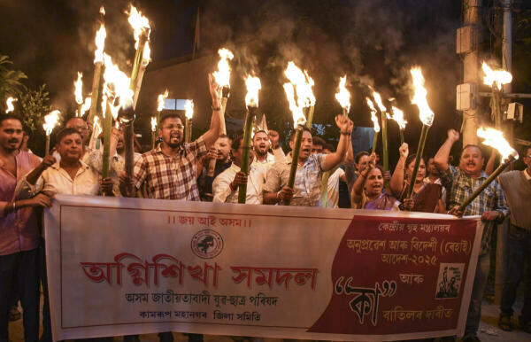 Activists of the All Assam Jatiyatabadi Yuba Chatra Parishad (AJYCP) raise slogans during a torch rally in protest against the BJP-led central government, in Guwahati, Assam.