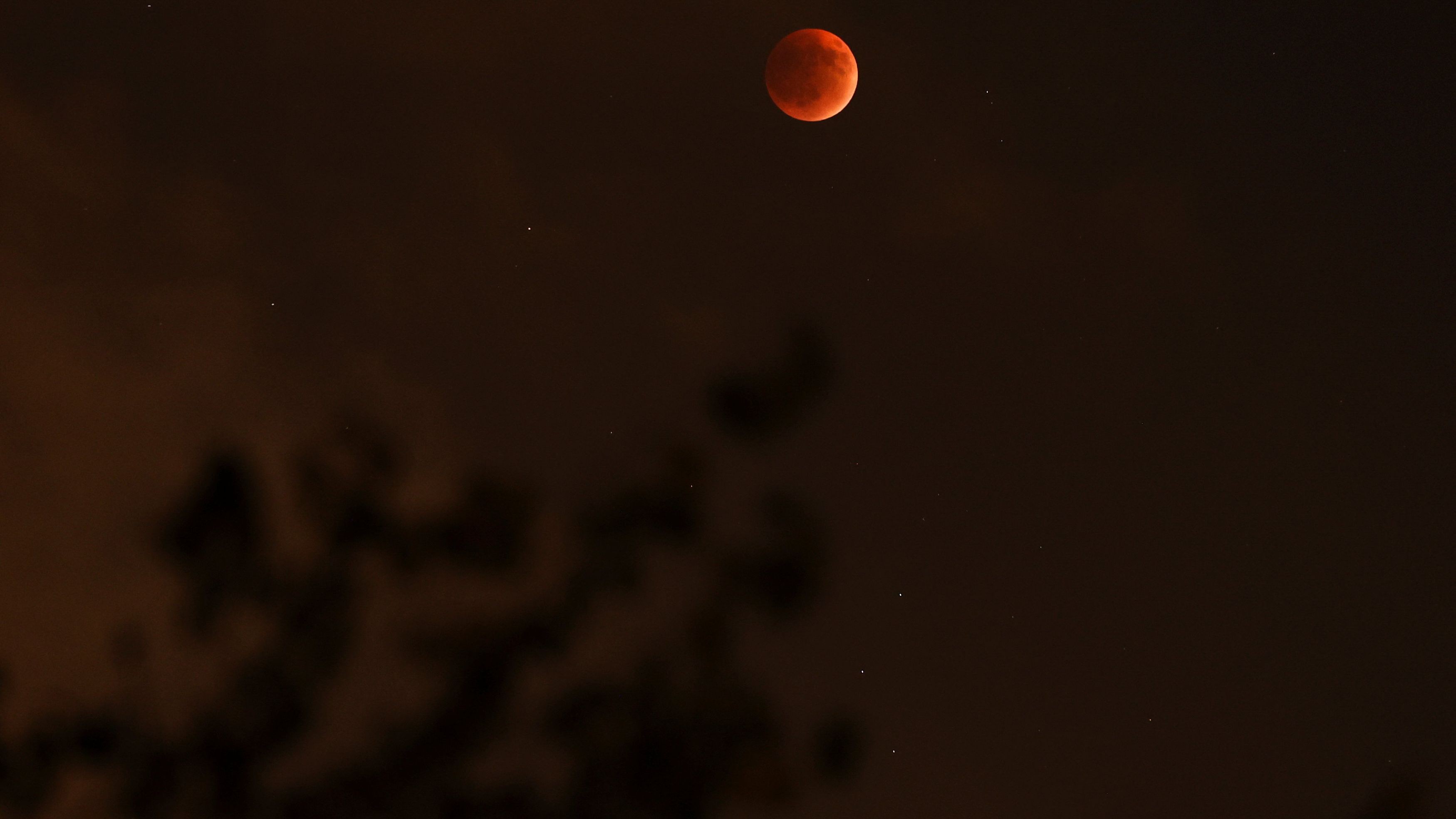 The 'Blood Moon' rises in the sky during a total lunar eclipse in Jerusalem.