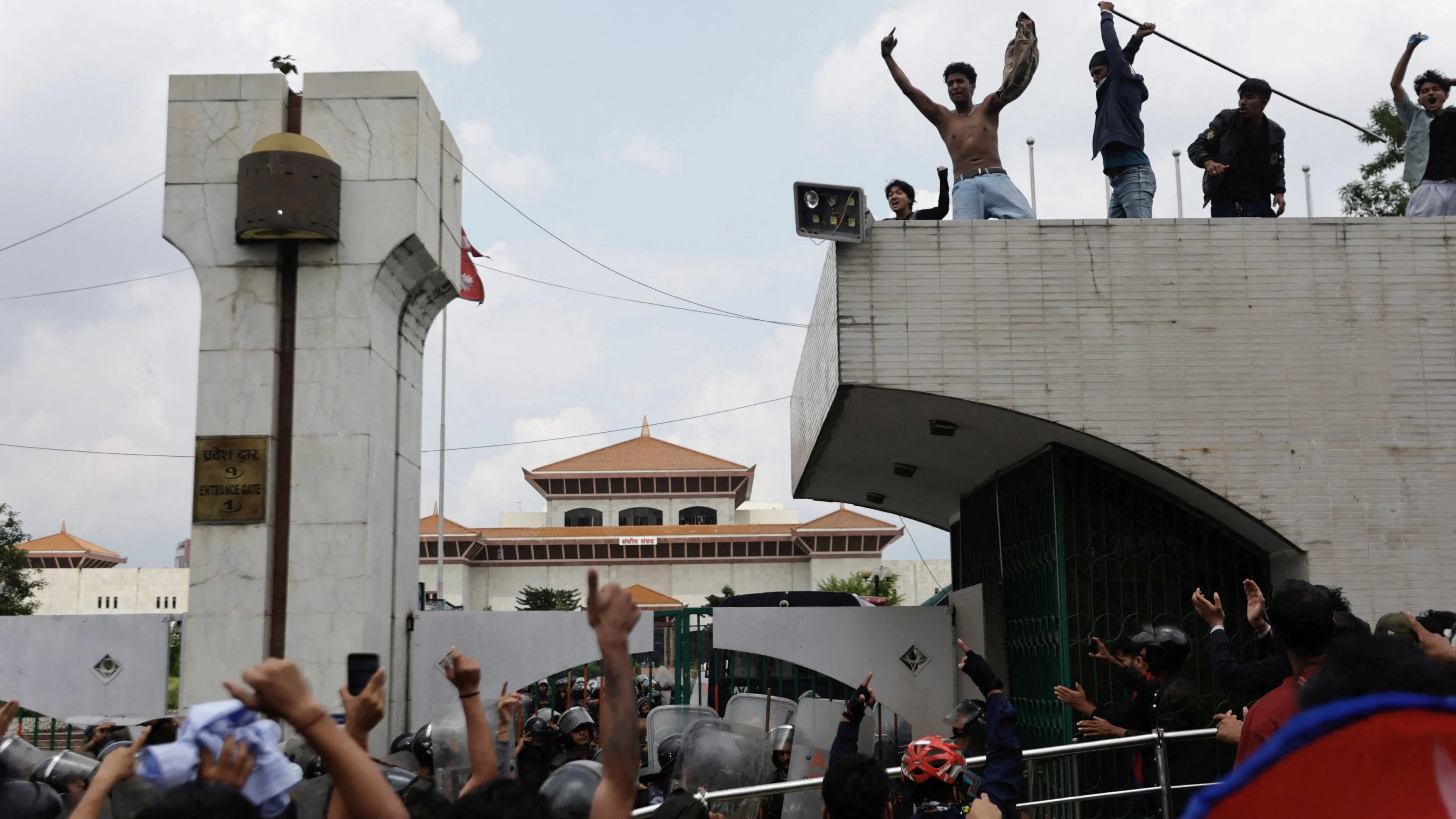 Demonstrators shout slogans as they stand atop the entrance of the Parliament during a protest against corruption and government’s decision to block several social media platforms, in Kathmandu, Nepal.