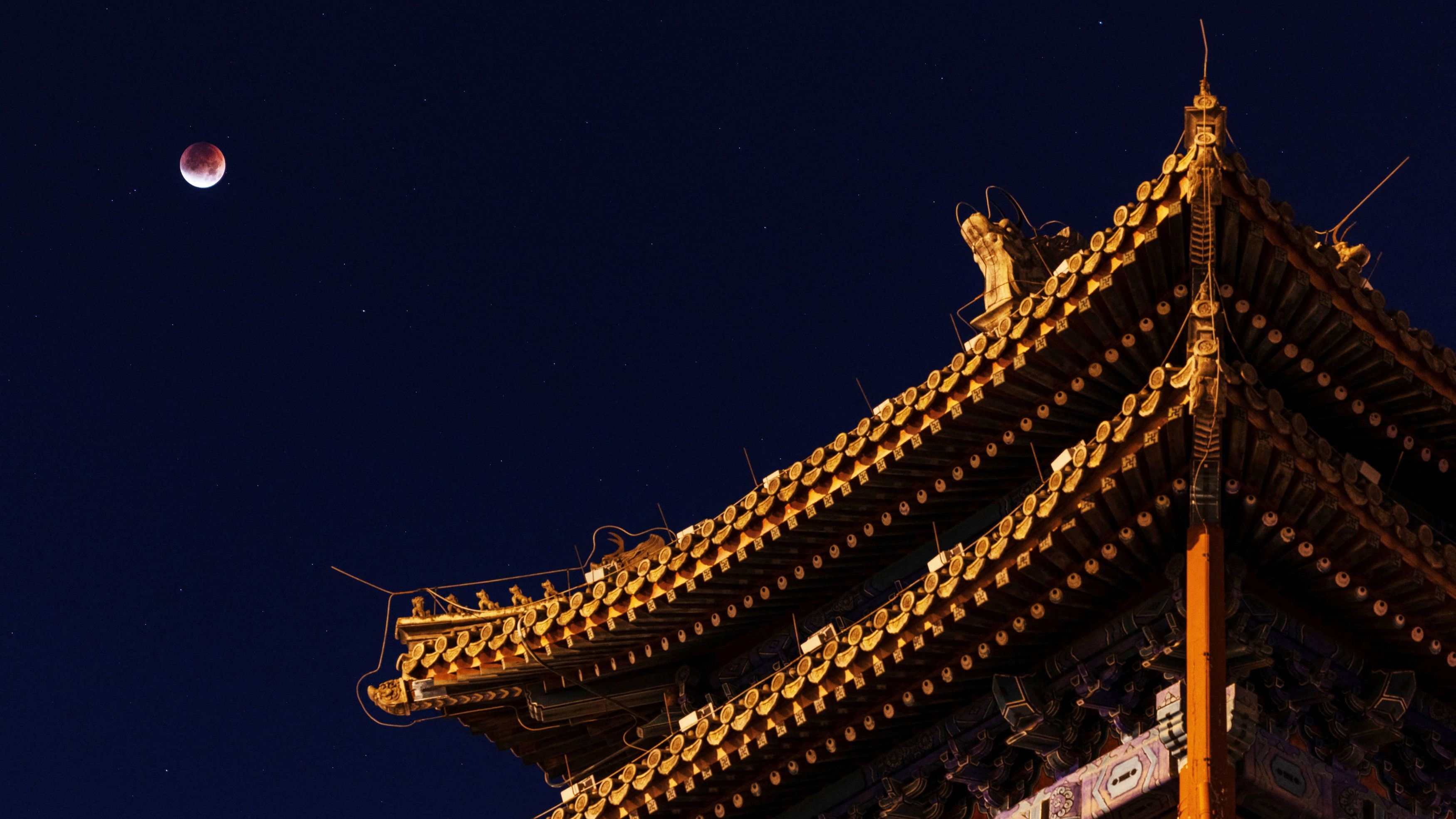 The 'Blood Moon' is seen over the roof of Yongdingmen Gate on the night of a total lunar eclipse in Beijing, China.