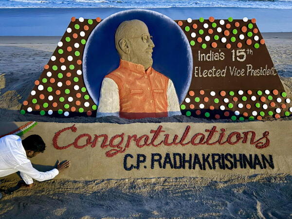 Artist Sudarsan Pattnaik creates a sand sculpture congratulating Maharashtra Governor C P Radhakrishnan after he was elected as 15th Vice President of India, at the beach in Puri, Odisha.
