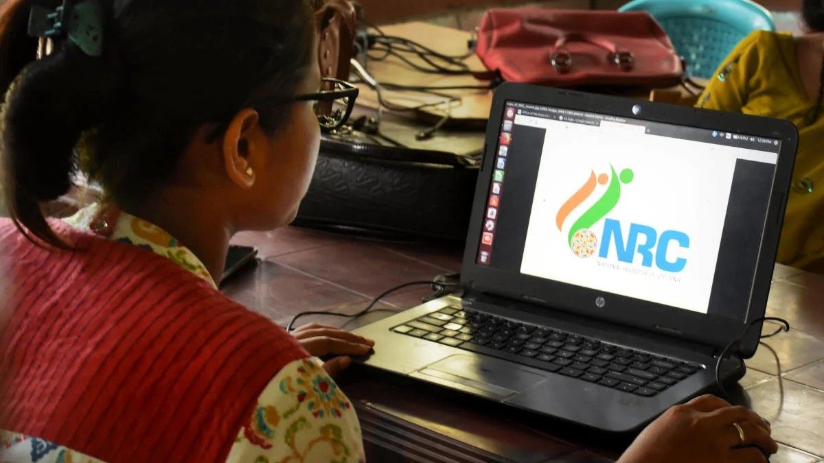 An official checks the documents submitted by people at a National Register of Citizens (NRC). 