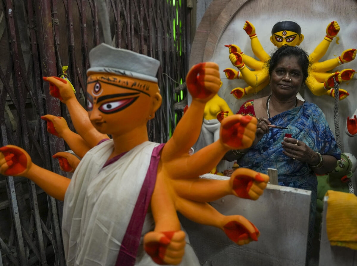 Clay artist China Paul gives final touches to an idol of Goddess Durga at her workshop, at Kumartuli, the potter's quarter in Kolkata.