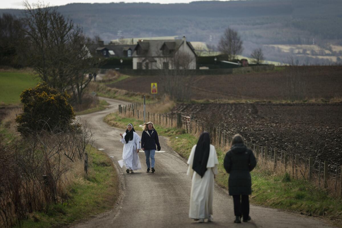Sister Bernadette Marie, 35, and Sister Mary Gianna, 41, of the Dominican Sisters of Saint Cecilia engage in conversation as they walk with attendees of the weekend retreat for Aberdeen Youth Ministers, outside of the grounds of Kilcoy Castle near Muir of Ord in the Highlands of Scotland, Britain.