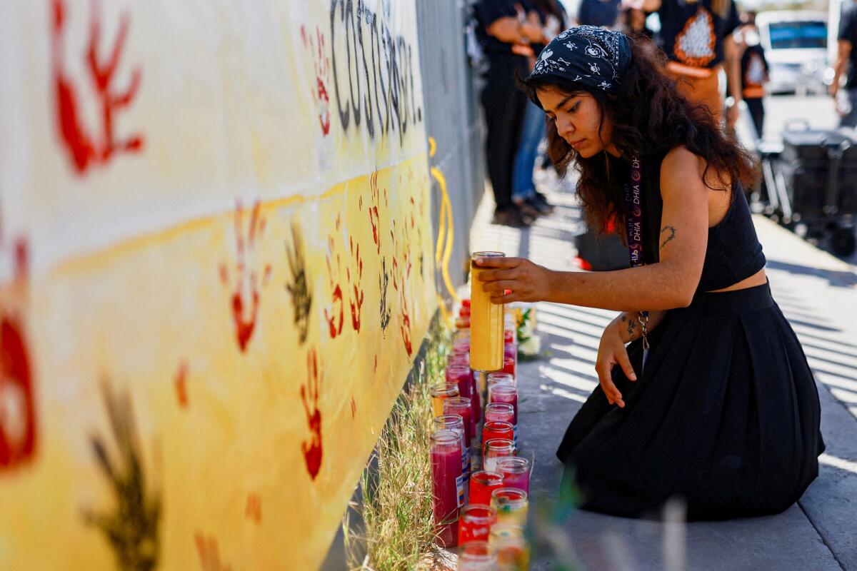An activist holds a candle during a protest outside a migration detention center in Ciudad Juarez, on the day Mexico’s former migration agency chief is due to issue a public apology over a 2023 fire at the facility that killed 40 migrants, in Mexico, September 26, 2025.