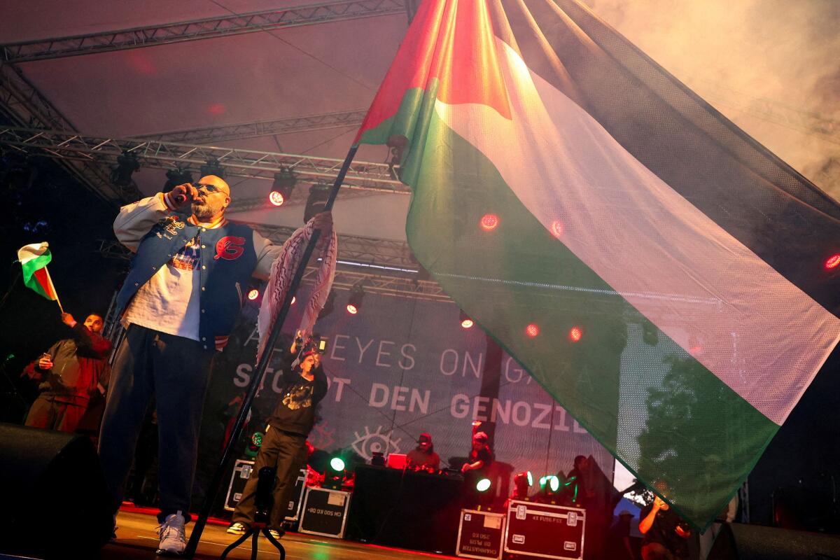 Rapper Massiv holds a Palestinian flag on stage during the "All eyes on Gaza" rally in Berlin, Germany, September 27, 2025.