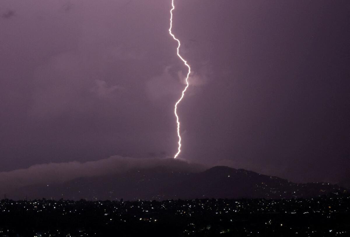 A lightning bolt strikes over the night sky as it rains in Kathmandu, Nepal 