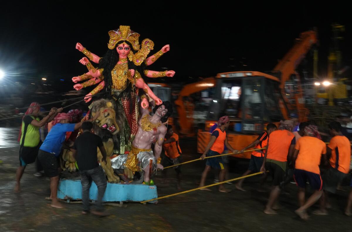 People carry an idol of Goddess Durga for immersion in the Hooghly River on ‘Vijayadashami’, marking the end of the ‘Durga Puja’ festival, at Babughat, in Kolkata, West Bengal