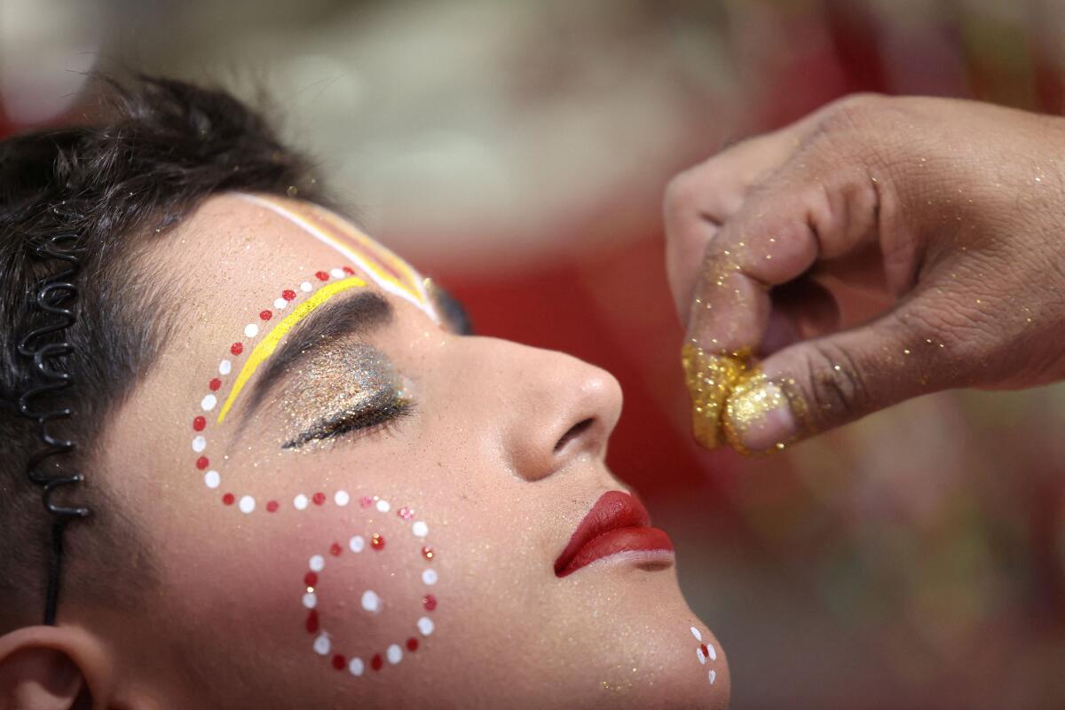 An artist dressed as Lord Rama prepares before a religious procession on the occasion of the Dussehra festival, or Vijaya Dashami, in Panipat