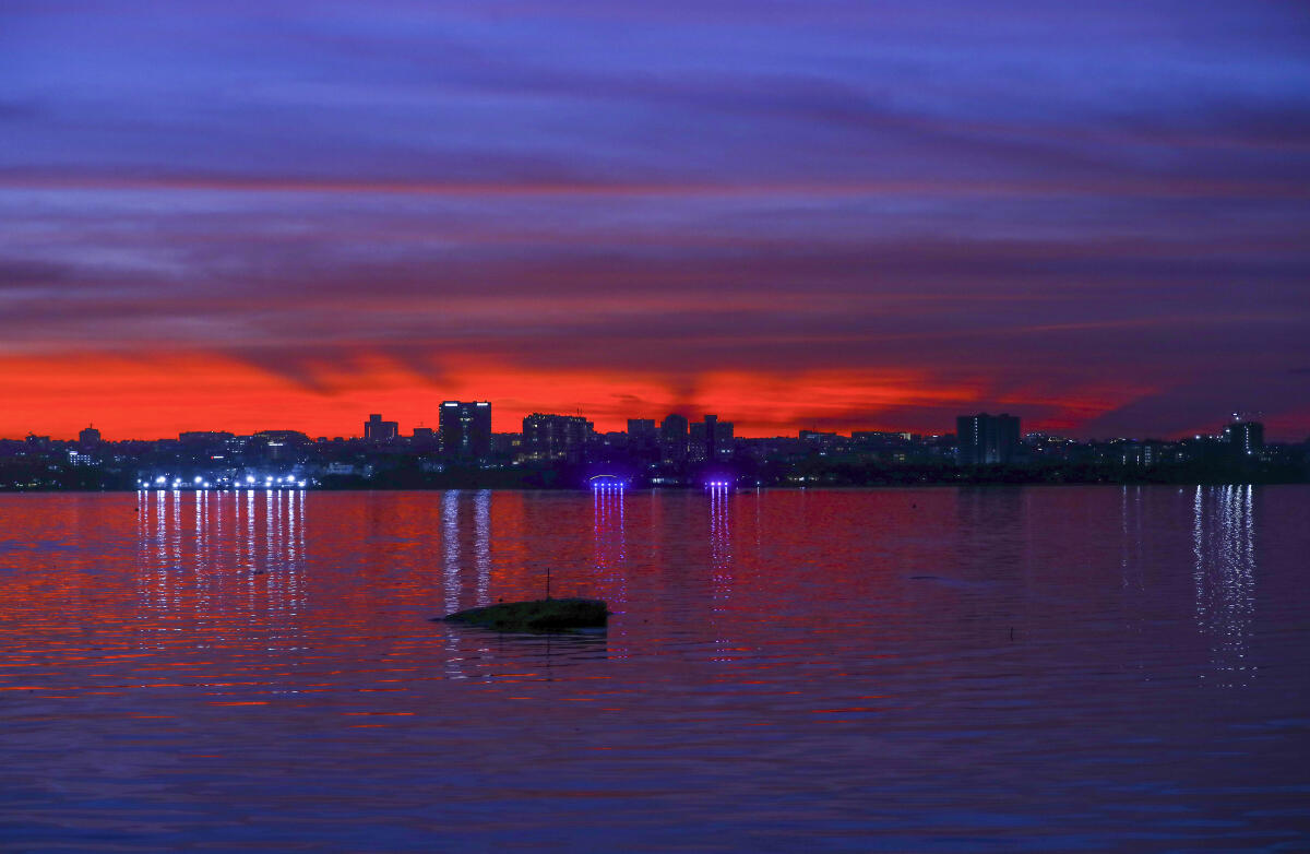 The Landscape is silhouetted during sunset as seen from the Hussain Sagar Lake, in Hyderabad, Telangana