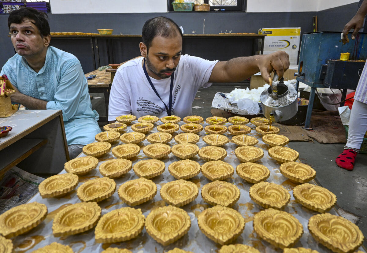 Persons with Disabilities prepare ‘diyas’, earthen lamps, ahead of the ‘Diwali’ festival at a workshop under the ‘Atmanirbhar Divyang Project’, in Ahmedabad
