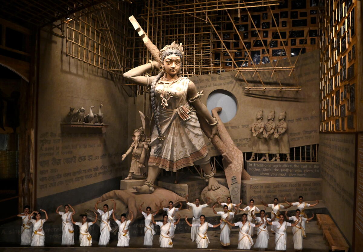 Artistes perform near an idol of Goddess Durga before its immersion at ‘Tala Prattoy’ community pandal, marking the end of the ‘Durga Puja’ festival, in Kolkata