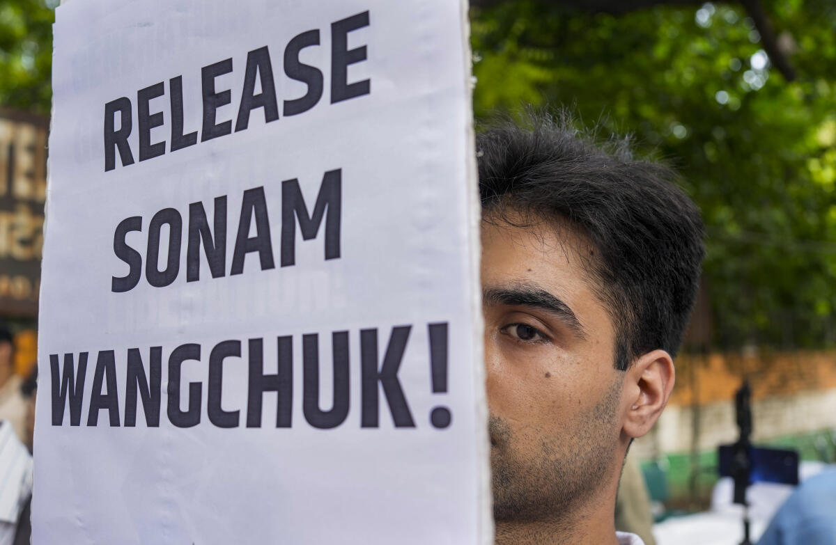 All India Students Association member holds a poster with 'Release Sonam Wangchuk' written on it during a demonstration in solidarity with Ladakh, at Jantar Mantar, in New Delhi