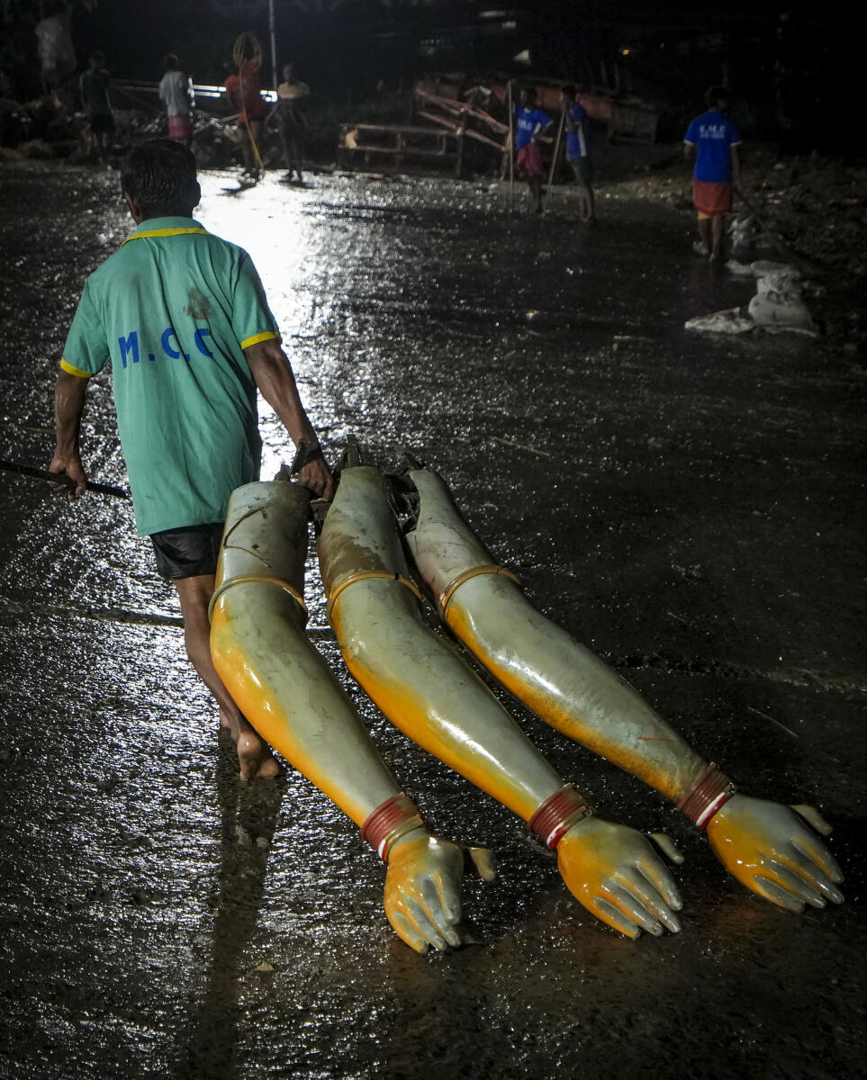 A man carries part of an idol of Goddess Durga at Babughat, after the ‘Durga Puja’ festivities, in Kolkata, West Benga