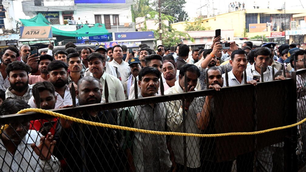 People gather outside a court during a hearing on the Madhya Pradesh cough syrup deaths case, in Chhindwara.