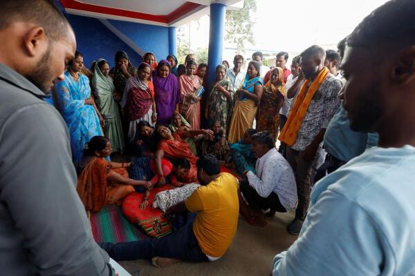 Family and relatives of Nilesh Suryavanshi mourn in front of his three-and-a-half-year-old child's body at their home in a village in Parasia, India, October 9, 2025. The child died after being admitted to a hospital following the consumption of Coldrif cough syrup, which has been linked to the deaths of several children.