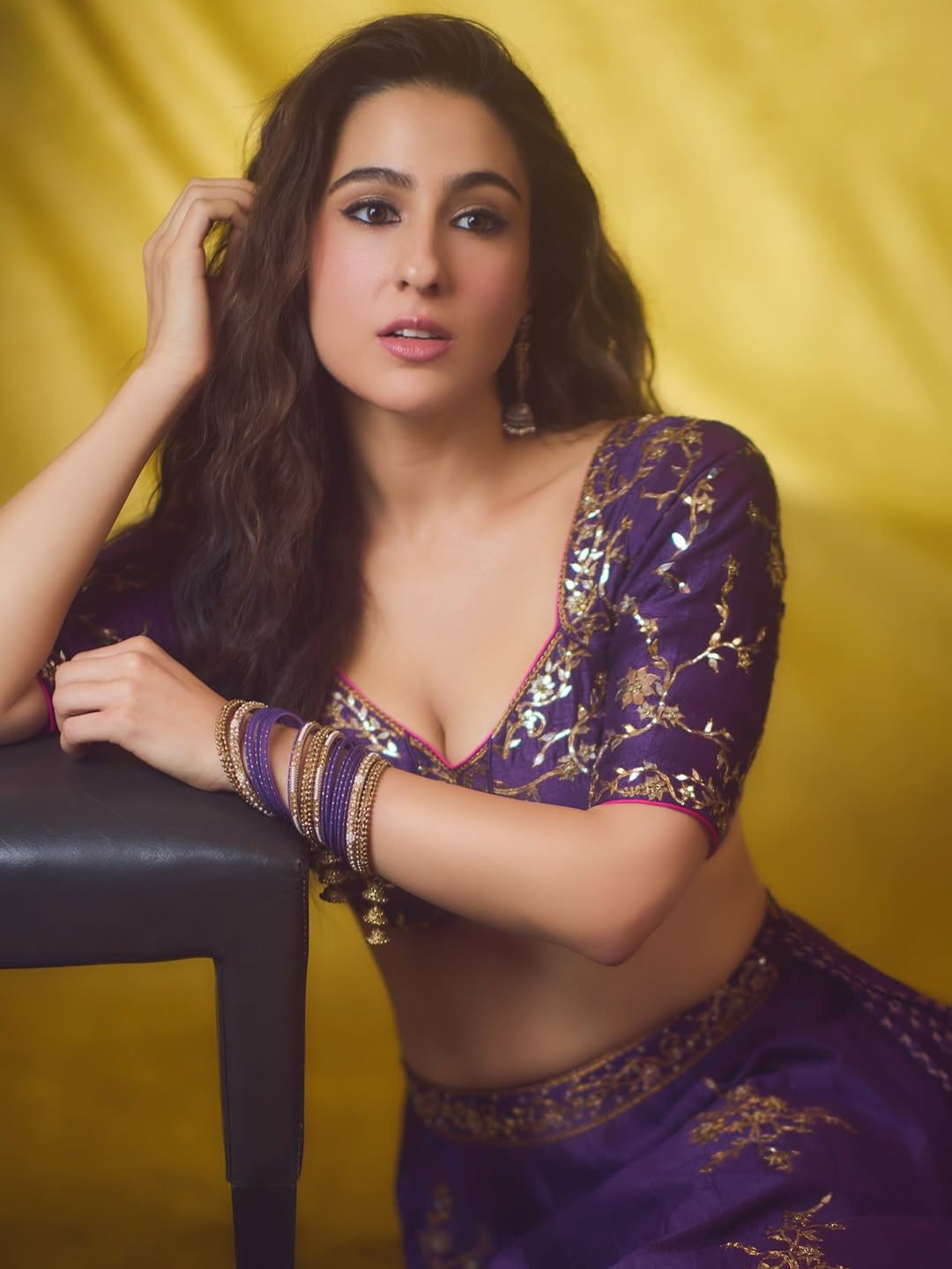 Illuminate the Diwali season in a mesmerizing dark aubergine tissue lehenga, beautifully detailed with intricate patra ka kaam, delicate dori accents, and golden embellishments that radiate regal elegance. The wide-neck, half-sleeved blouse, paired with matching bangles and delicate jhumkas, makes this ensemble both twirl-worthy and festive.