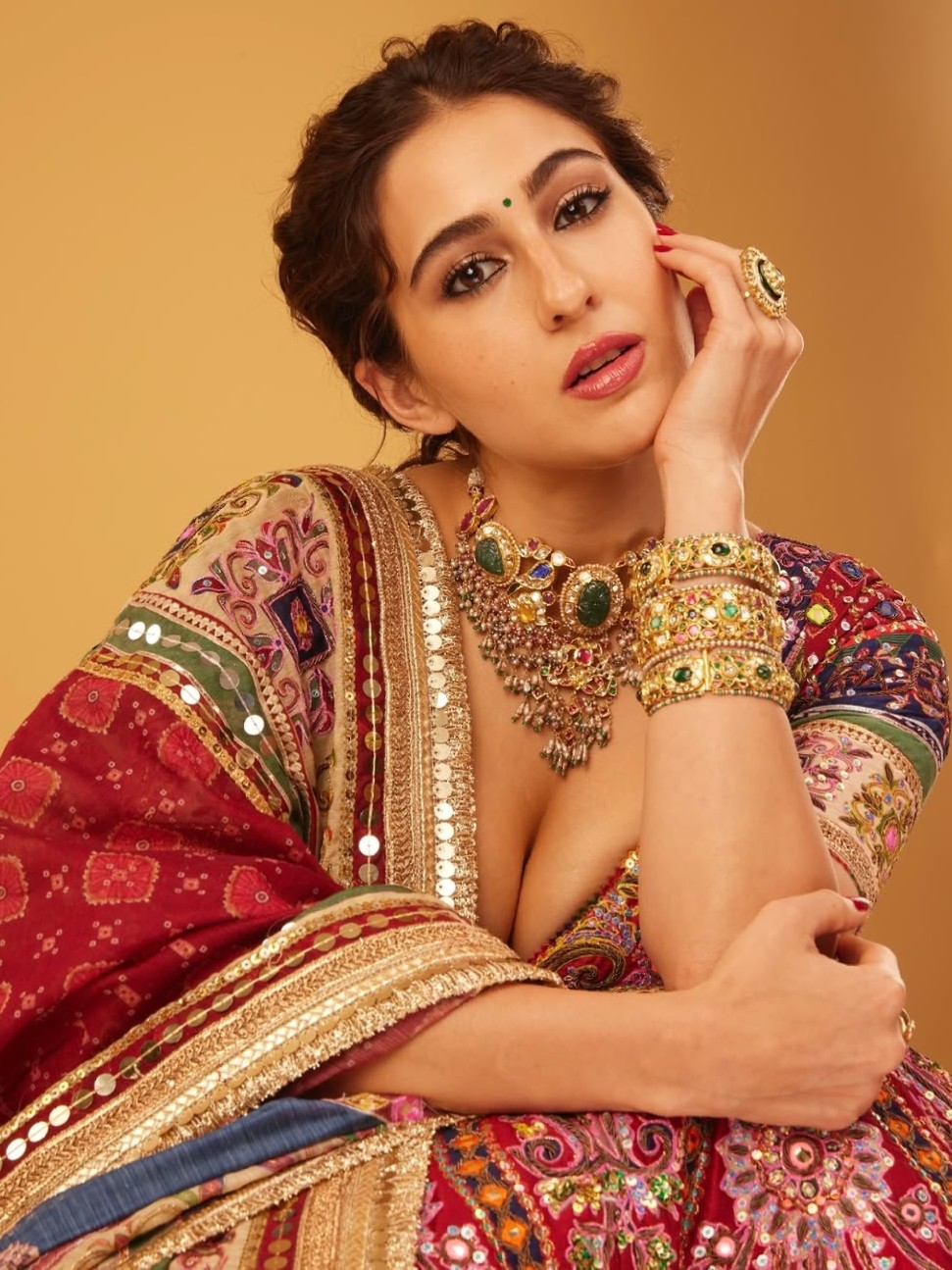 Sara's look radiated with shades of pink, from the choli to the blouse and dupatta, all showcasing exquisite Rajasthani-inspired embroidery and detailing. The blouse featured a sweetheart neckline and a dori-tied back, perfectly complemented by bold chooda bangles and a neatly braided ponytail, giving off an air of royal festive elegance.