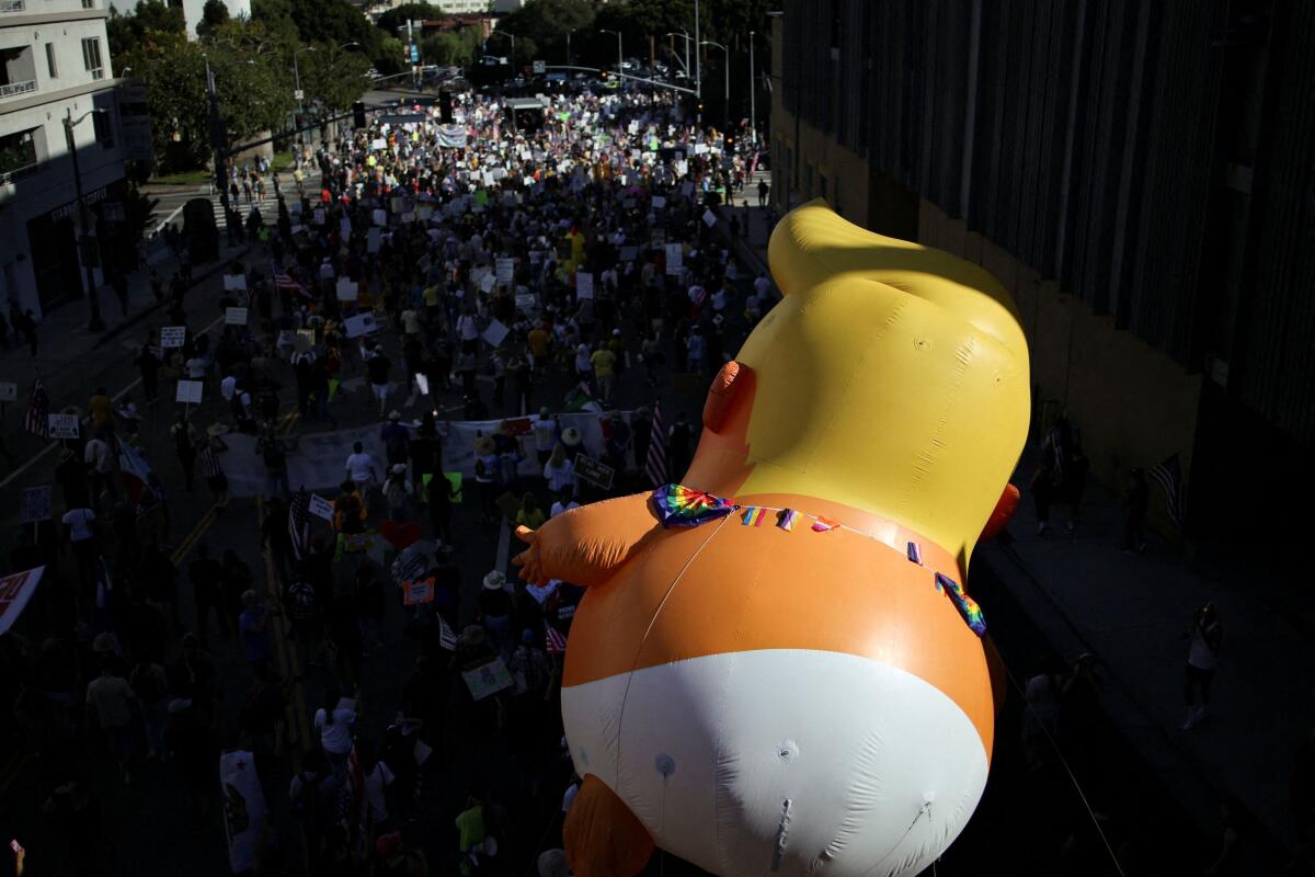 An inflatable balloon depicting U.S. President Donald Trump hovers above the crowd during a "No Kings" protest against U.S. President Donald Trump's policies.