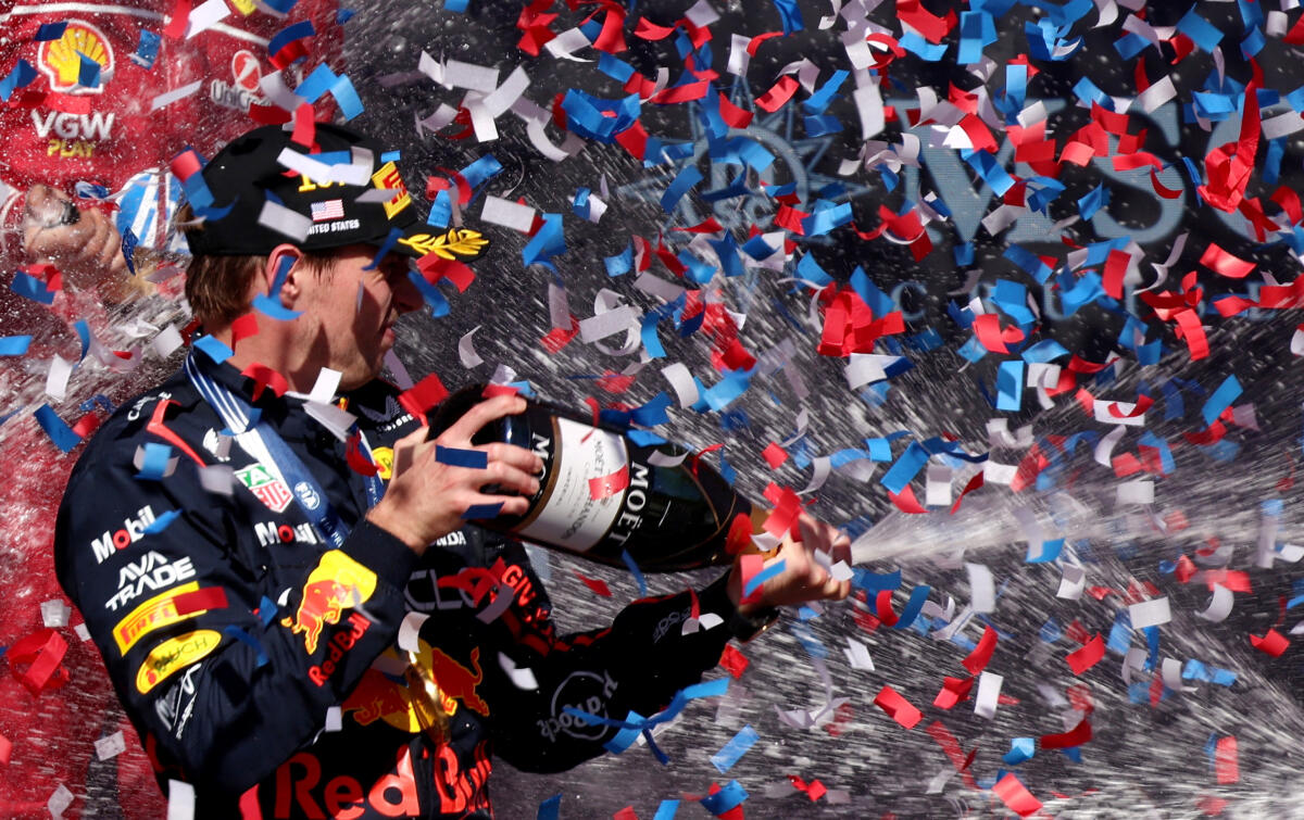 Red Bull's Max Verstappen celebrates with champagne on the podium after winning the United States Grand Prix.
