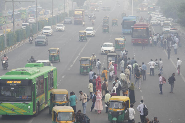 Commuters make their way amid low visibility as air quality deteriorates across Delhi-NCR, in New Delhi, Tuesday, Oct. 21, 2025.