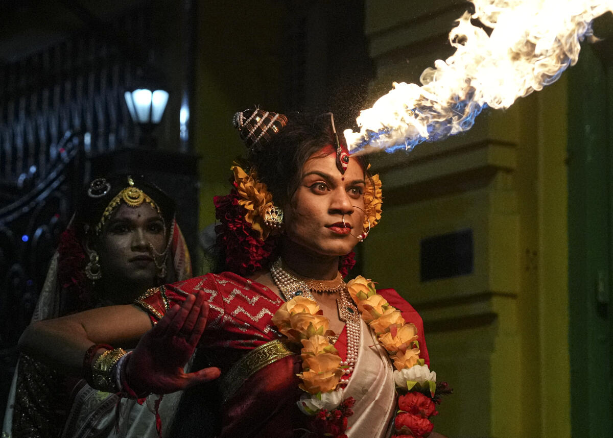 An artiste performs with fire during the immersion of an idol of Goddess Kali after the ‘Kali Puja’ festival, in Kolkata, West Bengal.