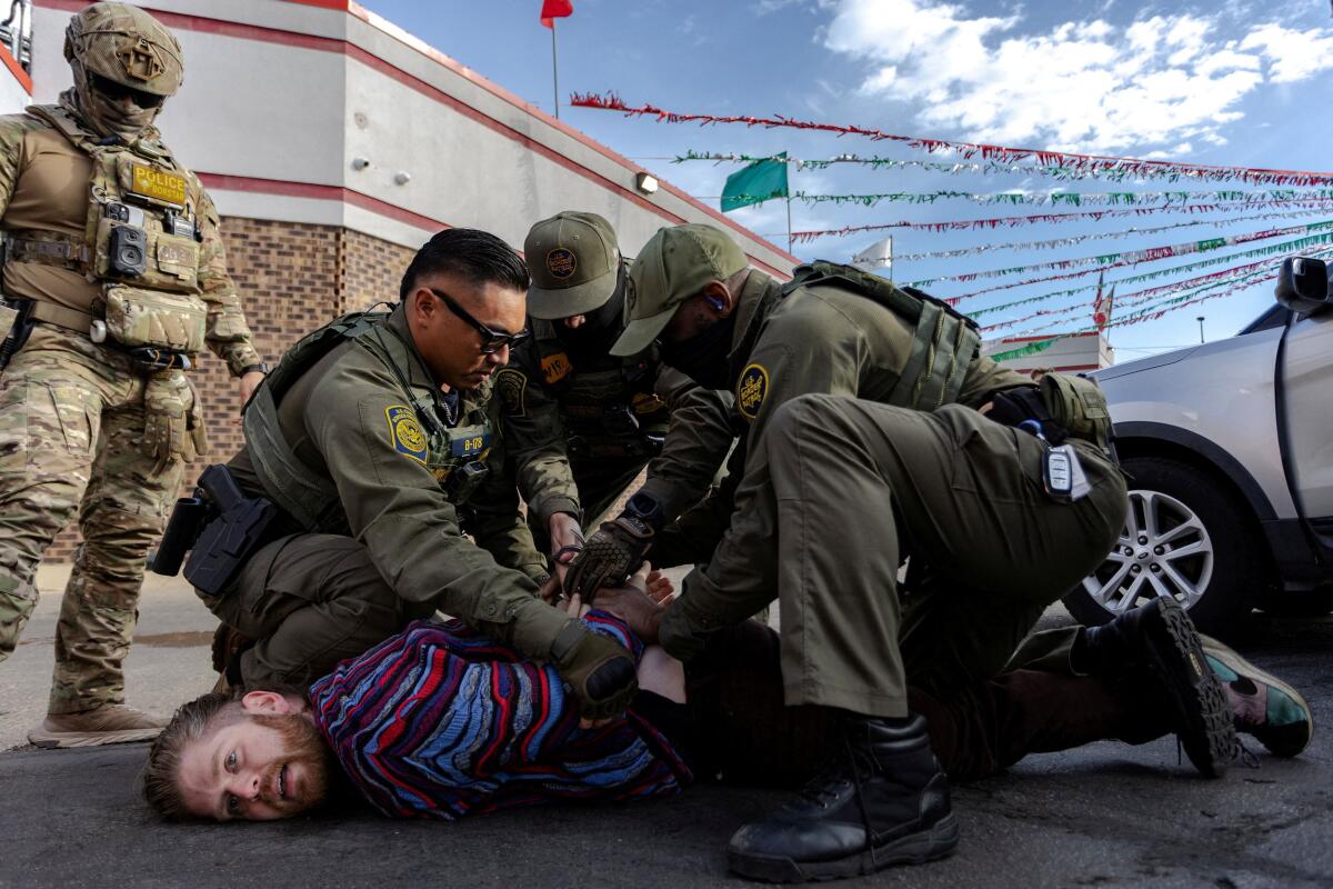 Federal agents detain a man in a parking lot in the Avondale neighborhood following a confrontation during immigration raids, after US President Donald Trump ordered increased federal law enforcement presence to assist in crime prevention, in Chicago, Illinois, US.