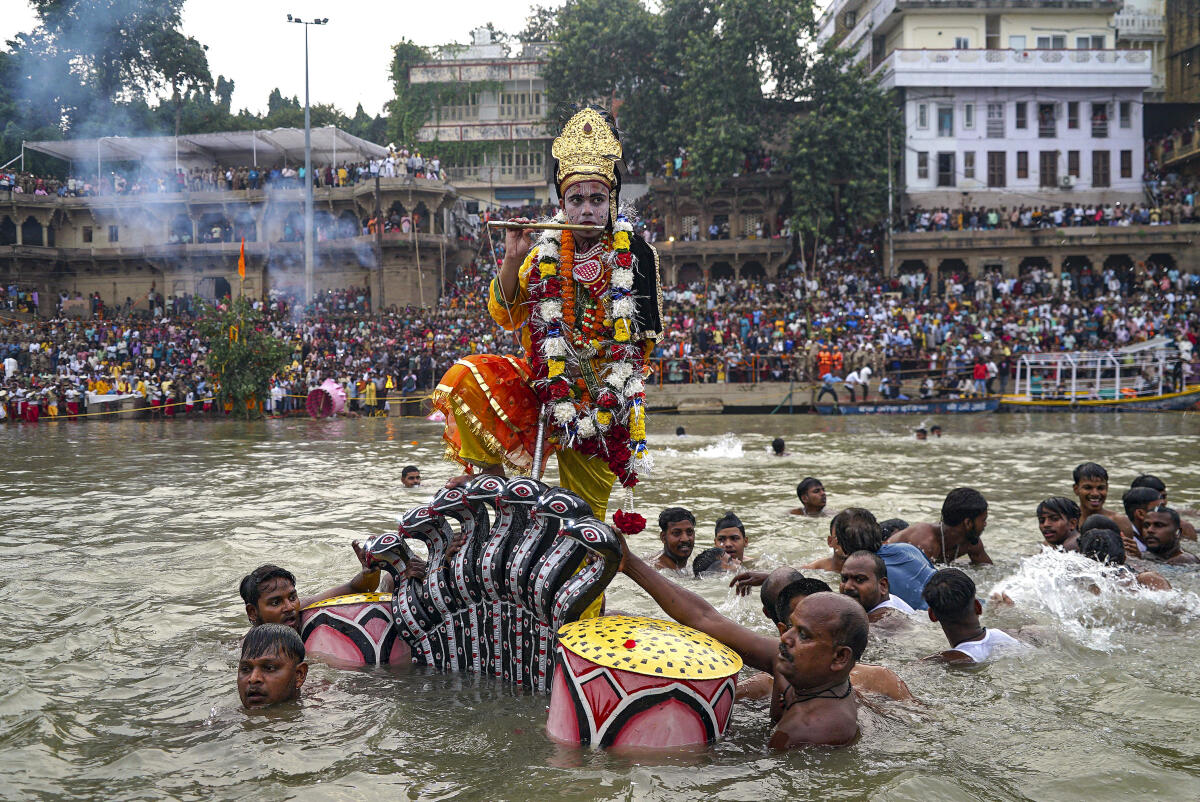 A man dressed as Lord Krishna with others during the ‘Nag Nathaiya Leela’ festival in the Ganga river at Tulsi Ghat, in Varanasi, Uttar Pradesh.