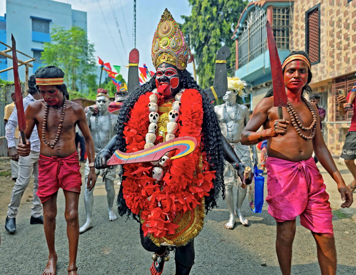 A man dressed as Goddess Kali with others during a procession ahead of ‘visarjan’, immersion, of an idol of the Hindu deity after the 'Kali Puja' festival, in Birbhum district, West Bengal.