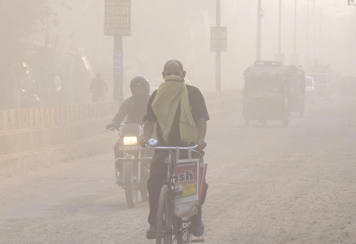 Commuters make their way amid low visibility as air quality deteriorates across Northern India, in Gurugram, Haryana