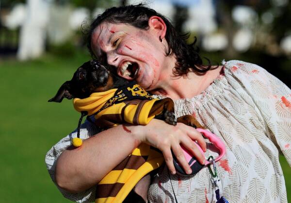 A participant holdng a dog reacts during Cape Town's Zombie Walk, held to raise funds for a local animal rescue, in Cape Town, South Africa.