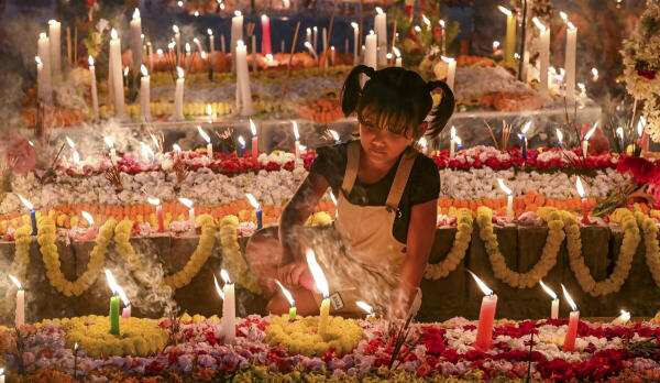 A child lights candles on a grave at a cemetery on ‘All Souls' Day’, also known as The Commemoration of All the Faithful Departed, in Nadia, West Bengal.