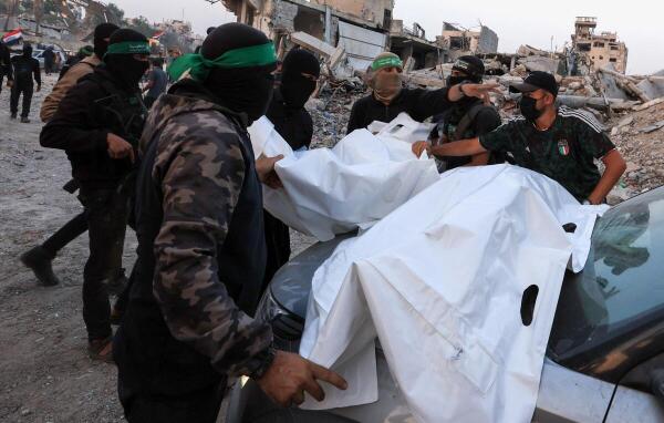 Palestinian Hamas militants carry bodies, after Hamas said that it found the body of an Israeli hostage soldier on Tuesday and prepares to return it to Israel through the Red Cross, in Gaza City.
