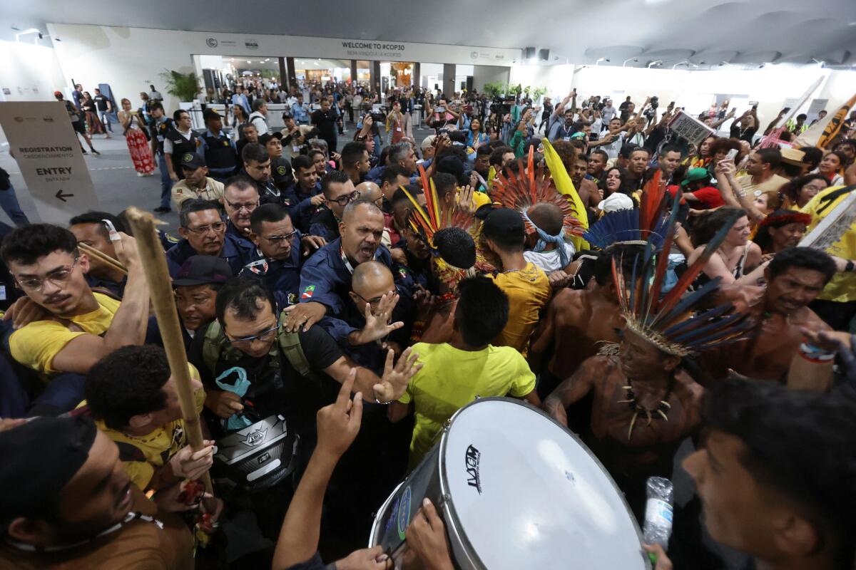 Demonstrators, including Indigenous people, take part in a protest as they force their way into the venue hosting the UN Climate Change Conference (COP30), in Belem, Brazil.