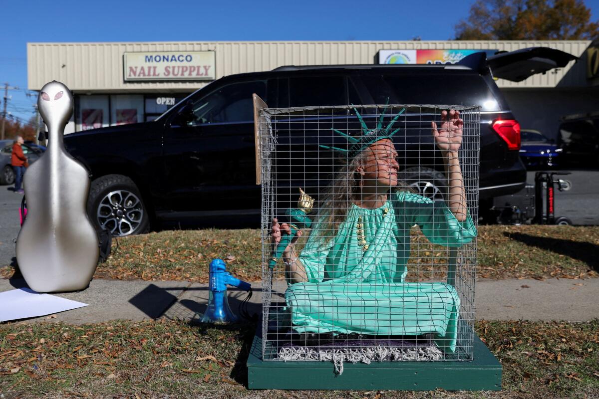 Shana Blake, a protestor wearing a Statue of Liberty outfit sits in a cage, as Members of the Customs and Border Patrol (CBP) conduct immigration raids on the streets of Charlotte, North Carolina, US.