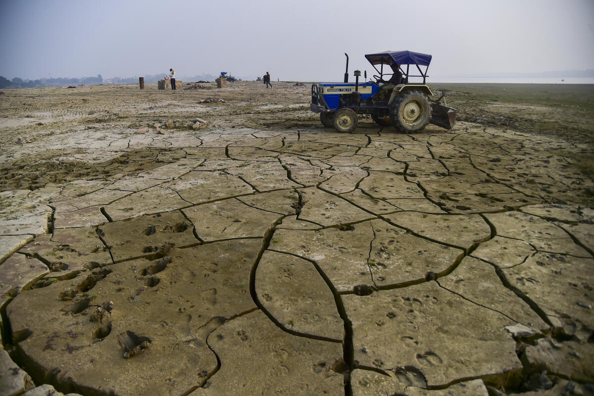 A worker uses a tractor to level the ground at a dried-up portion along the River Ganga as a part of preparations for the 'Magh mela 2026' festival, in Prayagraj.