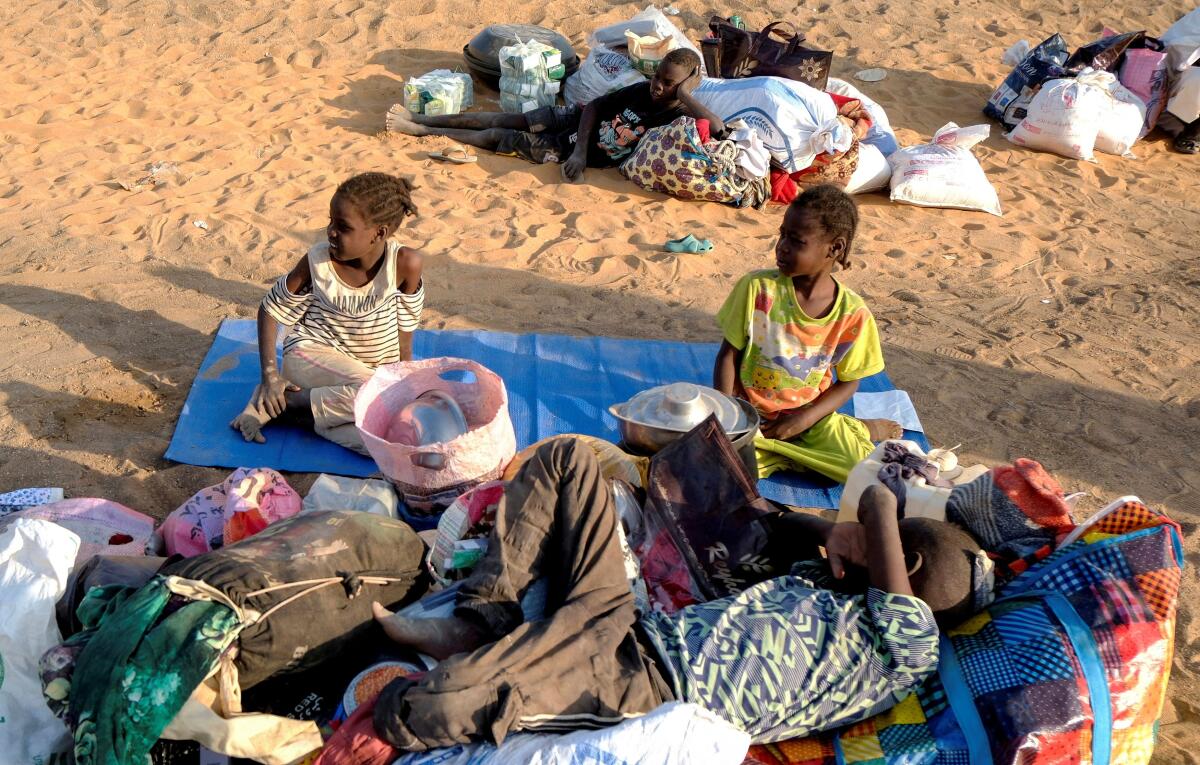 Children sit in a displacement camp in Al-Dabbah, Sudan.