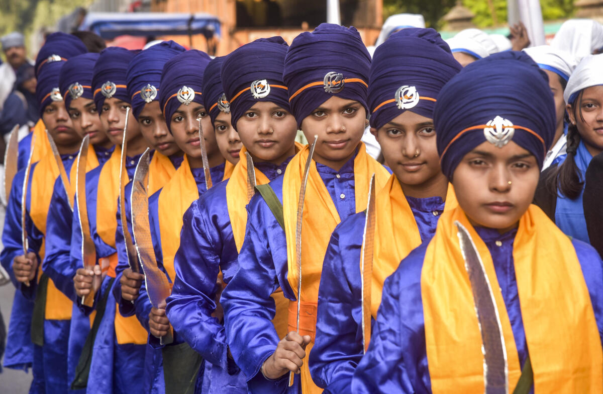 Devotees in traditional attire take part in a procession ahead of the 350th martyrdom anniversary of Guru Tegh Bahadur, in Varanasi, Sunday, Nov. 23, 2025.